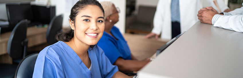 Portrait of secretary working at hospital reception stock photo