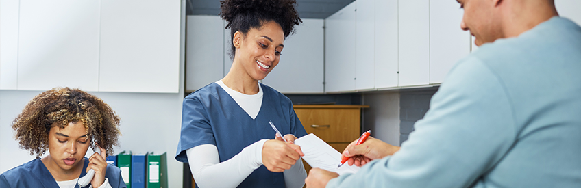 Healthcare Professionals Assisting a Patient at a Reception Desk